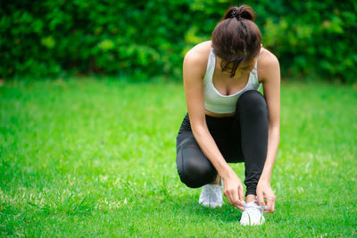 Full length of woman sitting on grass