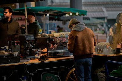 Rear view of people working at market