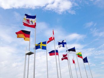 Low angle view of national flags against sky