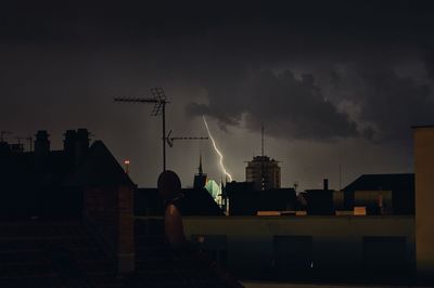 Cityscape against sky during lightning at night