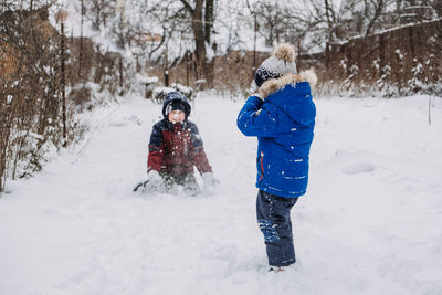 Outdoor winter activities for kids. kids playing in the suburbs, winter backyard gathering. boys