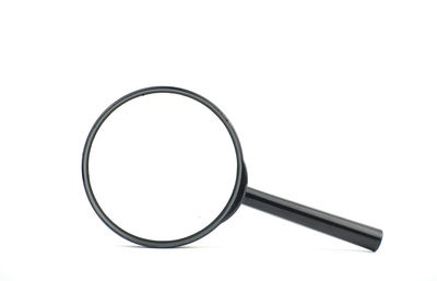 Close-up of magnifying glass on white background
