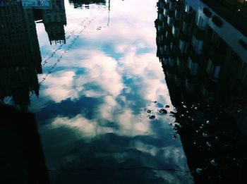 Buildings in city against cloudy sky