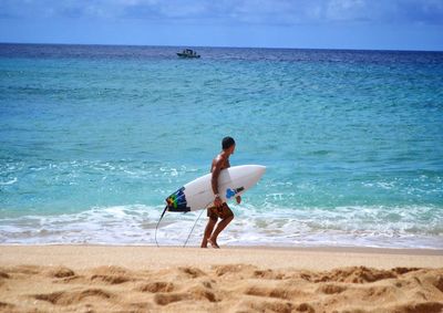 Full length of man surfing in sea against sky