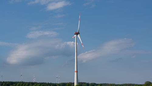 Low angle view of windmill on field against sky