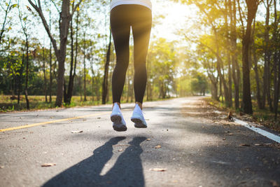 Low section of woman jumping on road