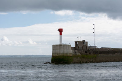 Lighthouse against cloudy sky