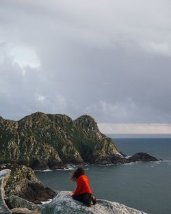 Rear view of woman looking at sea against sky