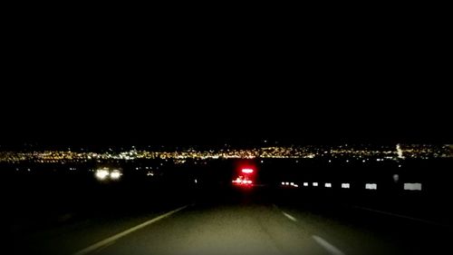 View of illuminated road at night