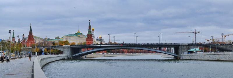 Bridge over river against buildings in city,moscow russia