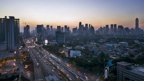 High angle view of street amidst buildings against sky during sunset