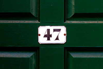 House number 47 on a dark green wooden front door 