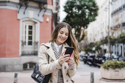 Young woman using mobile phone in city