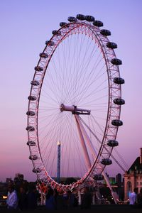 Low angle view of ferris wheel against sky at dusk