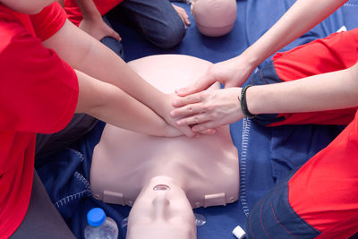 Volunteers giving first aid training with mannequin