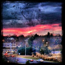Cars on road against cloudy sky
