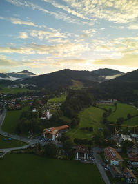 High angle view of townscape by sea against sky during sunset