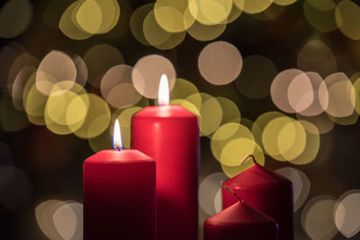 Close-up of illuminated candles against christmas lights