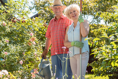 Portrait of smiling senior couple standing at backyard