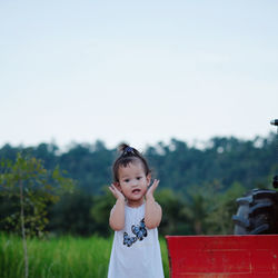 Portrait of cute baby girl standing on land