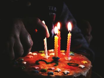 Close-up of hand holding candles