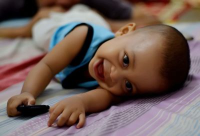 Portrait of cute baby lying on bed at home