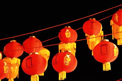 Low angle view of illuminated lanterns hanging at night