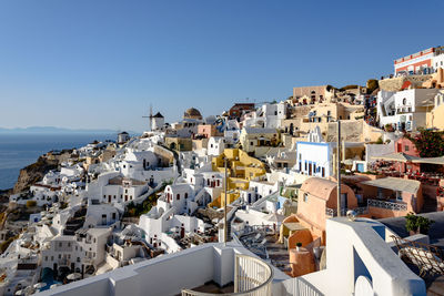 Town by sea against clear blue sky