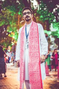 Man in traditional clothing looking away while standing on street