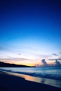 View of calm beach against blue sky