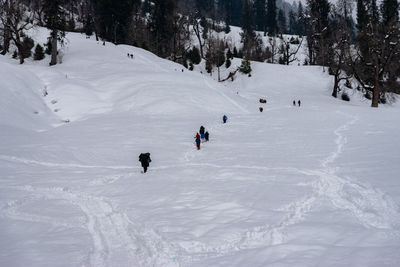 People hiking on snowcapped mountain