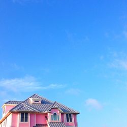 Low angle view of houses against blue sky