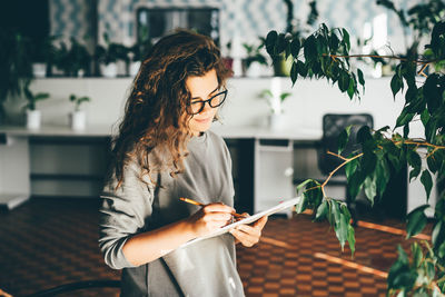 Freelancer woman using laptop at comfortable office, green co-working modern workplace