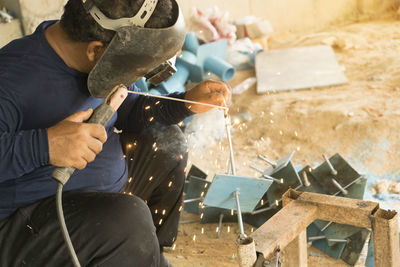 Man welding metal at workshop