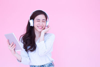 Portrait of smiling young woman using mobile phone