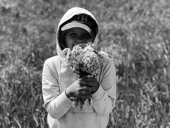 Portrait of girl holding umbrella standing on field