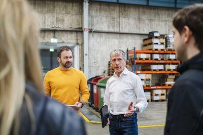 Businessman explaining employees in meeting at factory