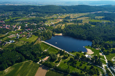 Aerial view of village and lake near mountains at summer day