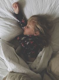 High angle view of girl sleeping on bed at home