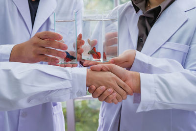 Midsection of couple holding hands