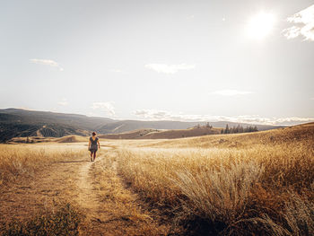 Woman  walking on field against sky