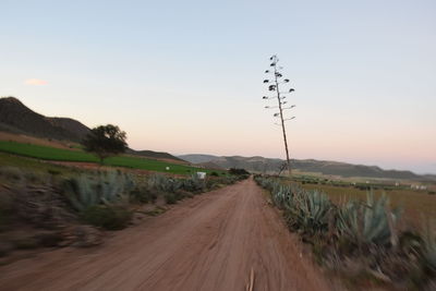 Road passing through landscape against clear sky