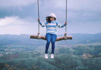 Full length of woman holding rope against mountain