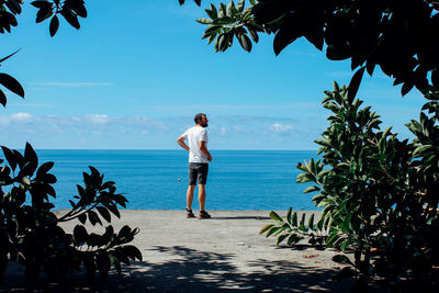 Full length of man standing at beach against sky