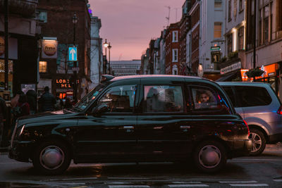 Car on illuminated city against sky