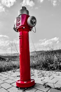 Red telephone pole against sky