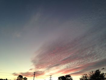 Silhouette of trees against cloudy sky