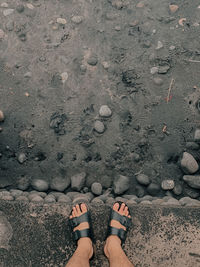 Low section of woman standing on sand