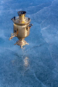 A retro copper samovar stands on the ice of the lake with a copy space. russian wood-fired kettle.