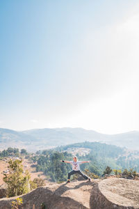 People sitting on mountain against sky